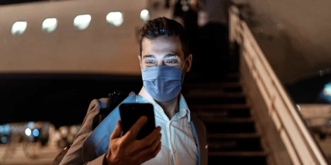 Businessman looking at his phone on a plane